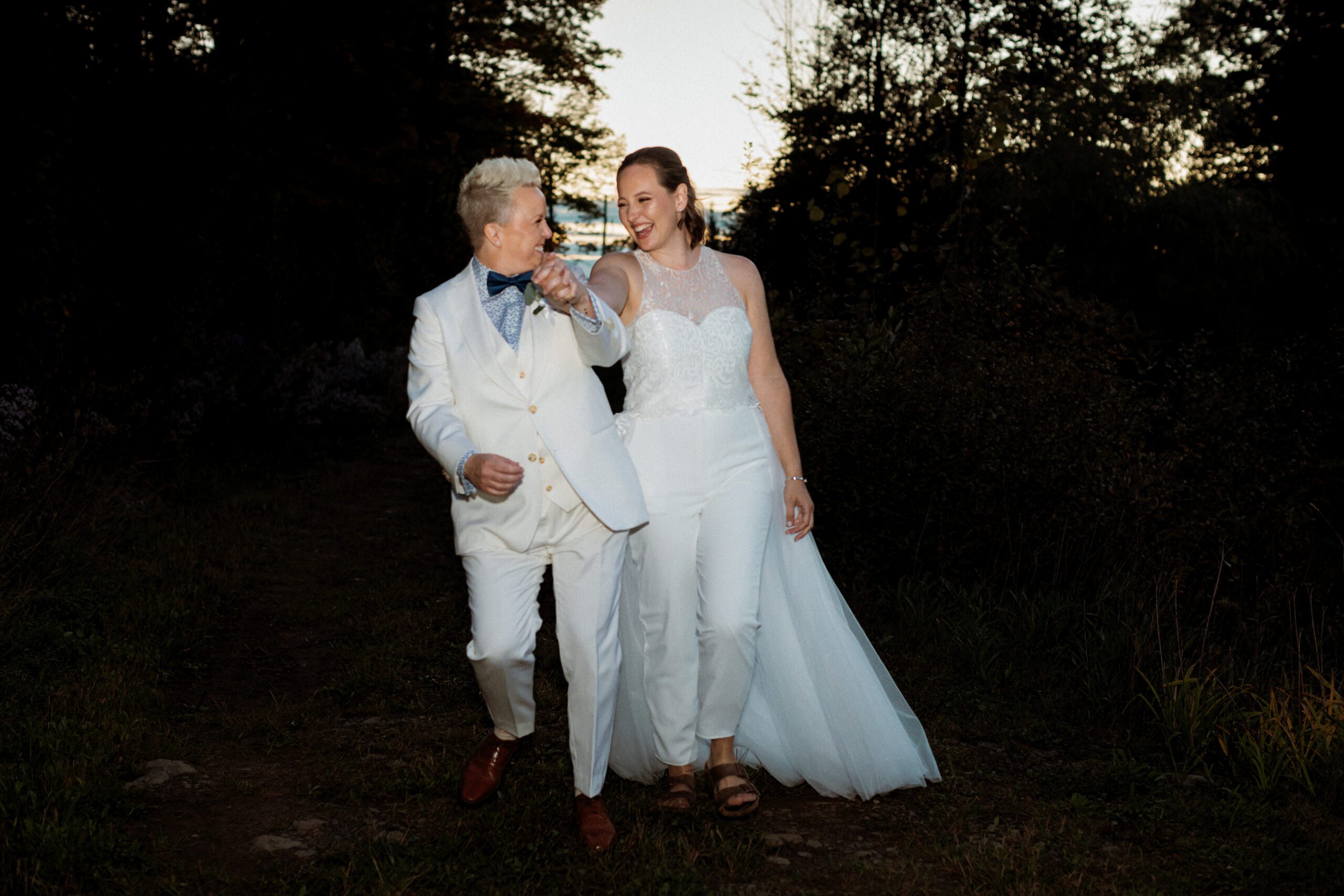 Shannon and Stacey walking in the dusk light on their Metcalfe backyard wedding day