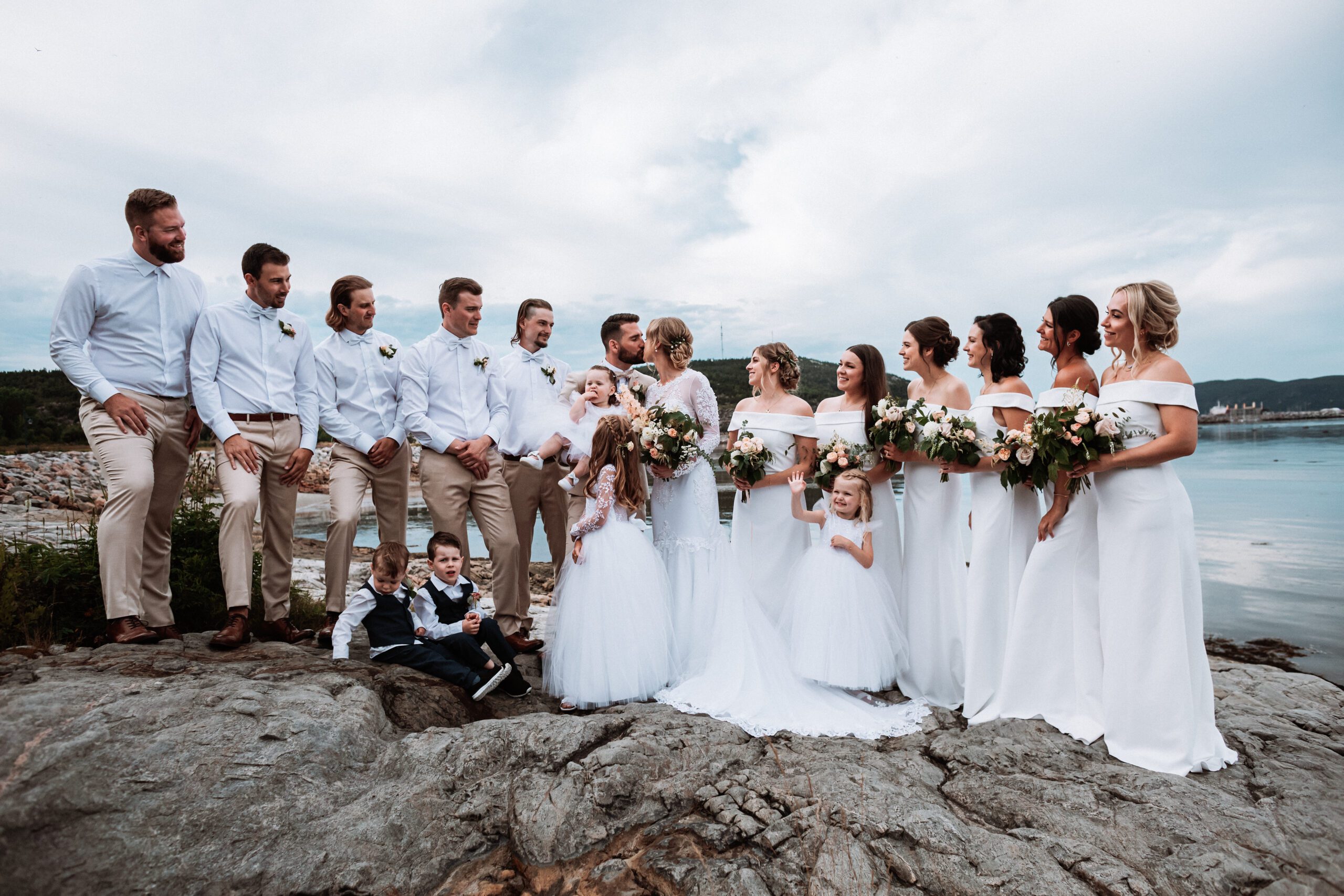 all white wedding party standing on the shores of the St Lawrence River in Baie-Comeau