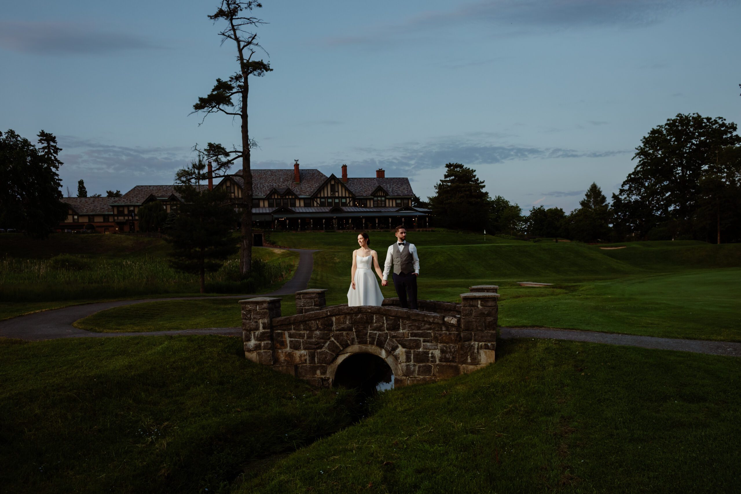 Bride and groom posing on a little bridge near the Royal Ottawa Golf Club